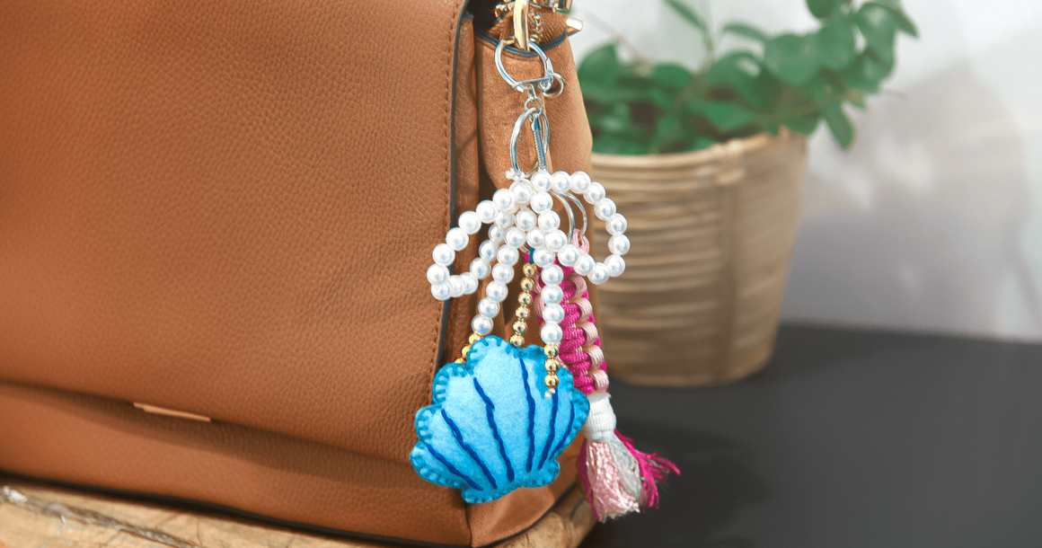Bag Charm mit Muschel, Schleife und Knüpfanhänger